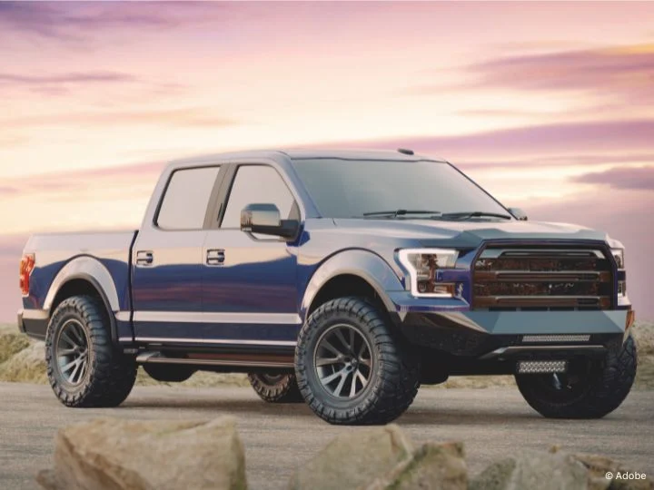 A blue RAM pickup truck is parked on an empty road.