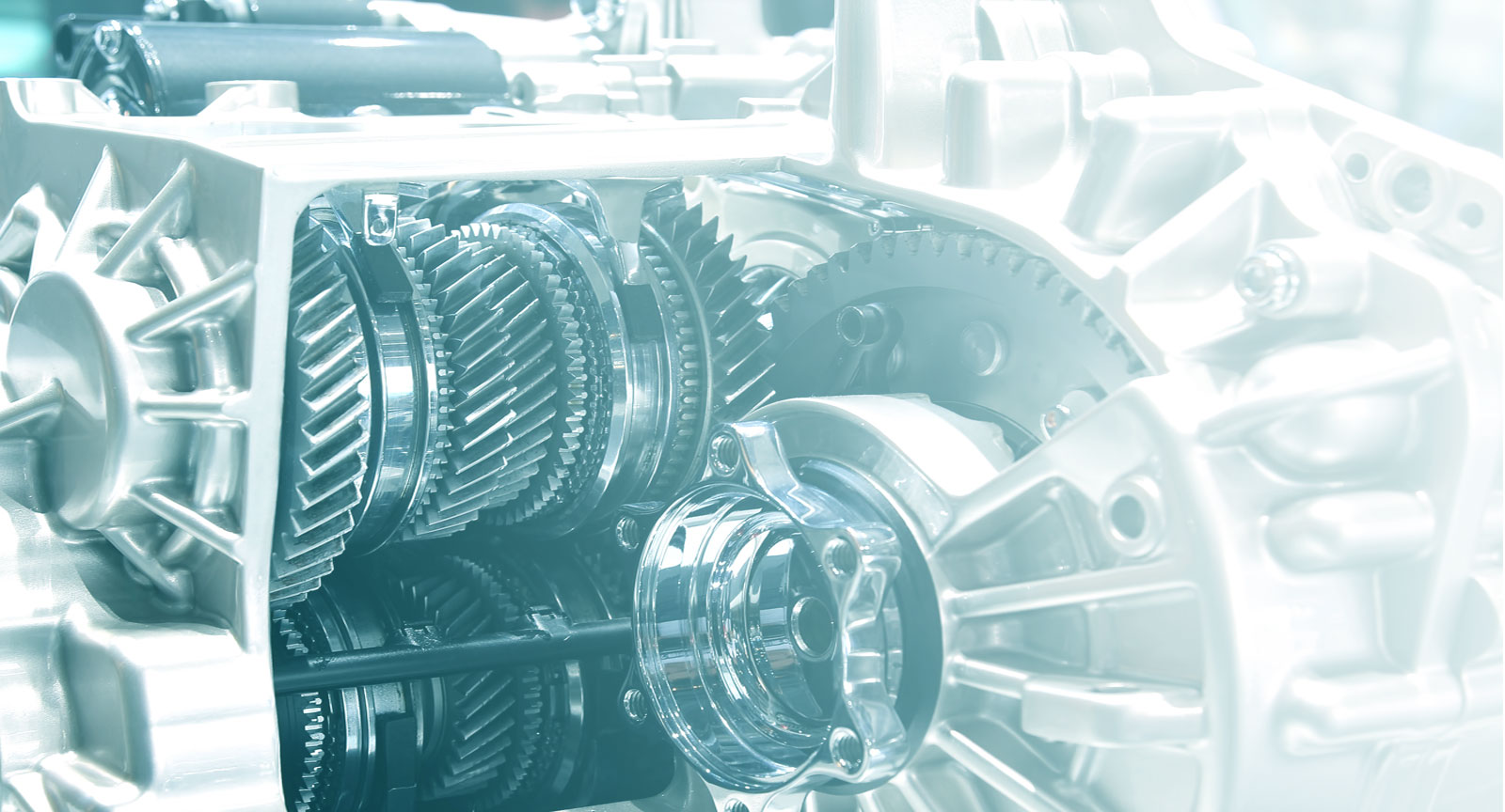 A close-up shot of the gears of a transmission, with a blue and white overlay on top of the image.